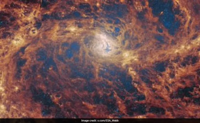 पास के सर्पिल आकाशगंगा में छिपने वाले एक सुपरमैसिव ब्लैक होल के संकेत